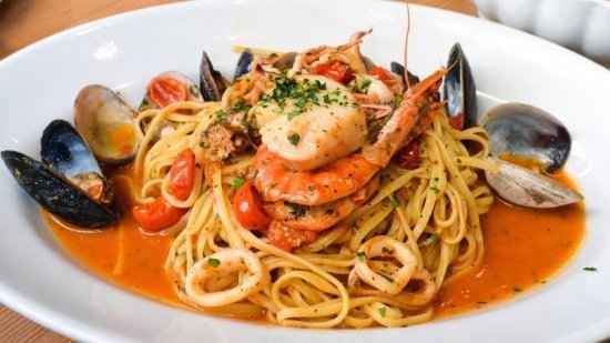 Italian seafood spaghetti with shrimp, mussels, and tomato sauce on white plate, Nostrale Gourmet