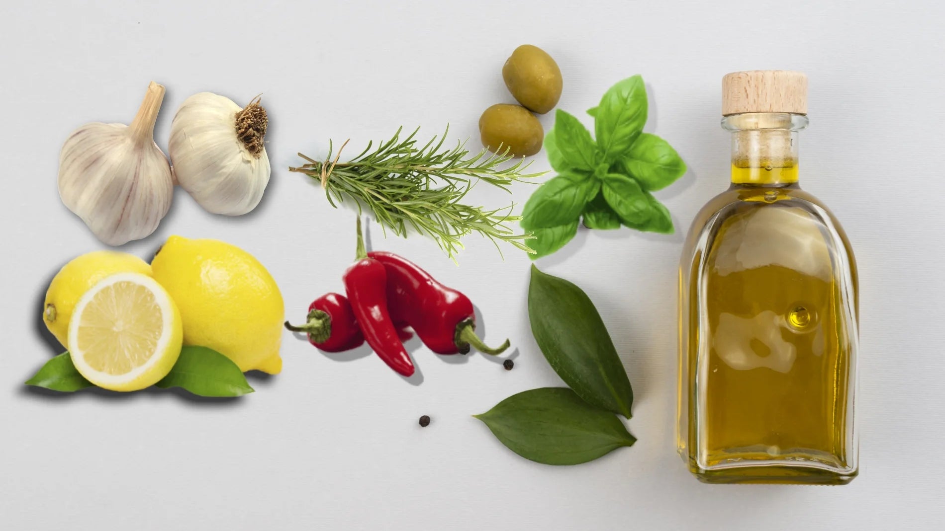 Bottles of Italian extra virgin olive oil with olives, lemon, chili peppers, and basil