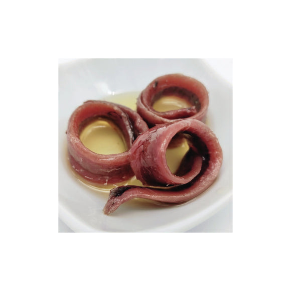 Filetti di acciughe del Mar Cantabrico immersi nell'olio extravergine di oliva, con colore rosato e consistenza morbida.
