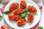 Piatto di bruschette con pomodoro e olio EVO al basilico- Nostrale Gourmet